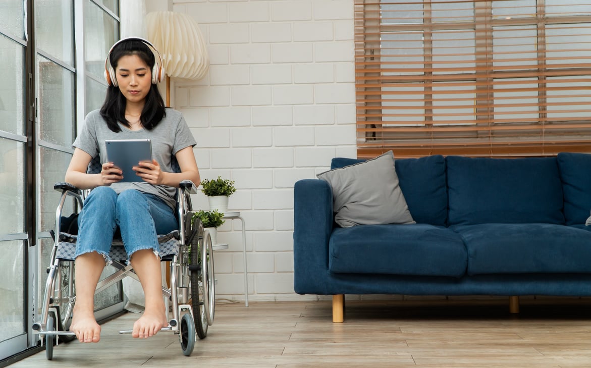 Happy disabled Asian woman sitting in a wheelchair And worki